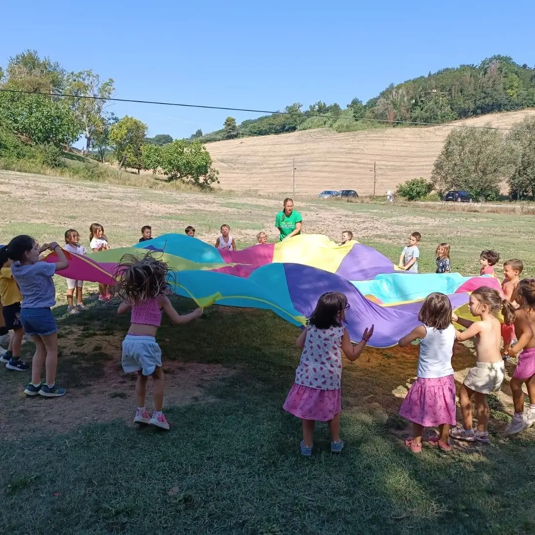 Bambini che giocano con un telo colorato
